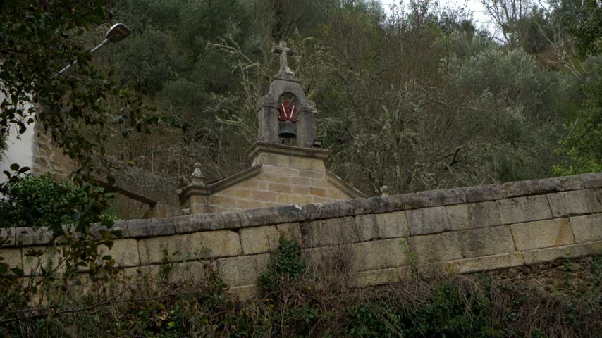 View of the historic Capela da Nosa Señora das Ermidas in Portomourisco, Petín, Galicia, Spain, surrounded by trees and the peaceful rural landscape of the Xares River valley.