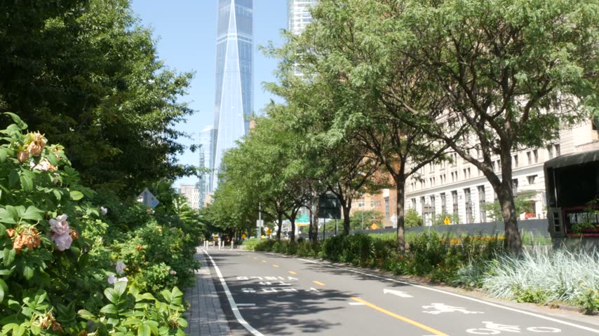 Lower Manhattan Downtown Financial District, New York City, United States. One World Trade Center skyscraper building, Freedom tower from Battery park. Summer trees greenery, West street perspective.