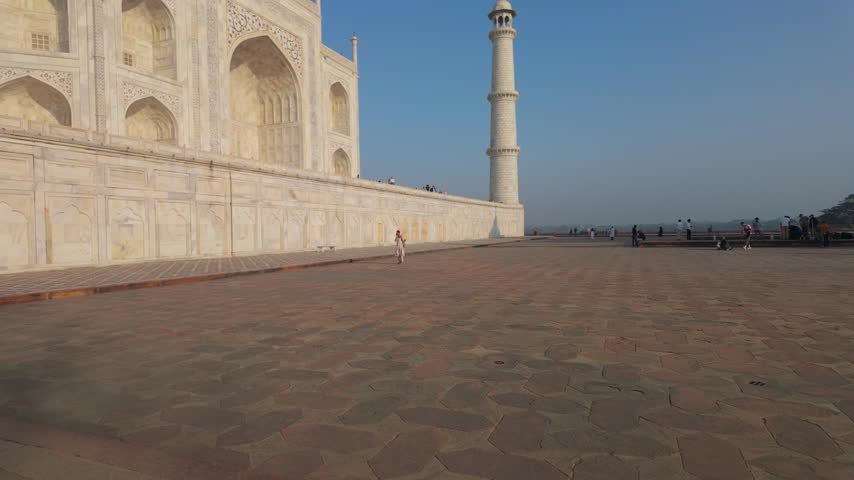 A wide shot of the iconic Taj Mahal in Agra, India, showcasing the intricate white marble architecture and minarets under a clear blue sky. Suitable for travel documentaries and cultural heritage cont