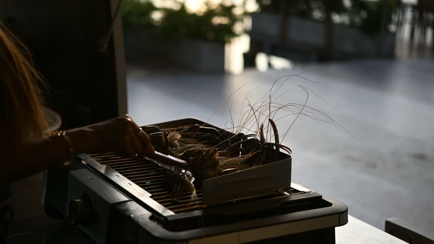 The cooking demonstration shows shrimp being grilled on a stove, with only the hands and the stove visible.