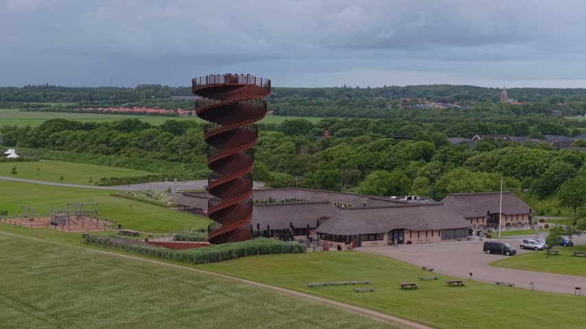 Aerial drone footage of Marsk Tower surrounded by windswept marsh grass, where the wind creates striking natural patterns across the Wadden Sea landscape in Denmark.