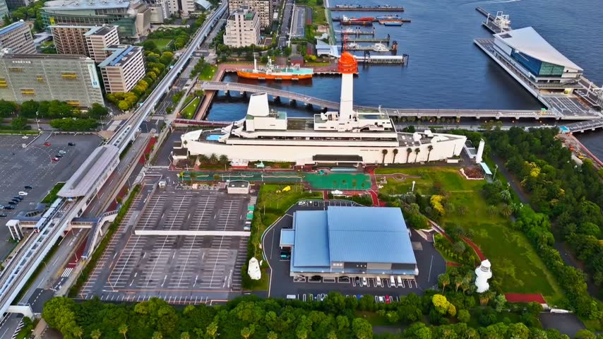High-resolution aerial drone footage showing Yokohama waterfront, harbor, cruise terminal, lighthouse, modern buildings, roads, ships, and urban architecture along the bay in Japan. Ideal for travel, tourism, transportation, business, cityscape, coastal development, and Japanese urban lifestyle content.