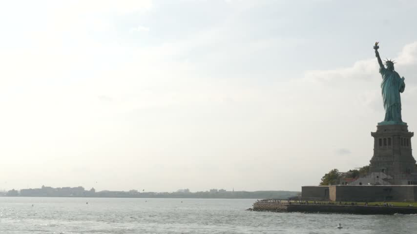 Statue of Liberty on Liberty Island, New York, United States. Cooper monument, symbol of democracy and patriotism near Manhattan, NYC USA. View from ferry boat, tourist cruise.