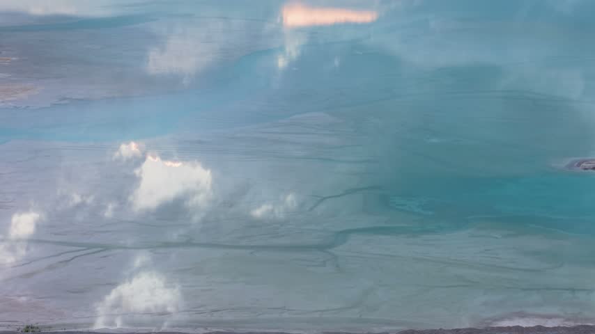 White clouds reflect across vivid turquoise quarry water with subtle mineral patterns near Port Dolomite in Michigan.