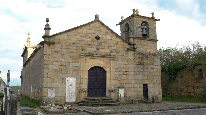 Stone facade of Santa Maria church in Toen, Ourense, Galicia, Spain with bell tower, open full establishing