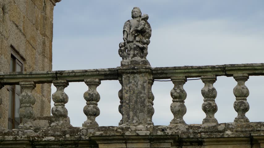 Stone statue beside balustrade at San Pedro de Moreiras church in Toen, Ourense, Galicia, Spain