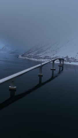 Cars driving over a snowy bridge in Lofoten islands, Norway