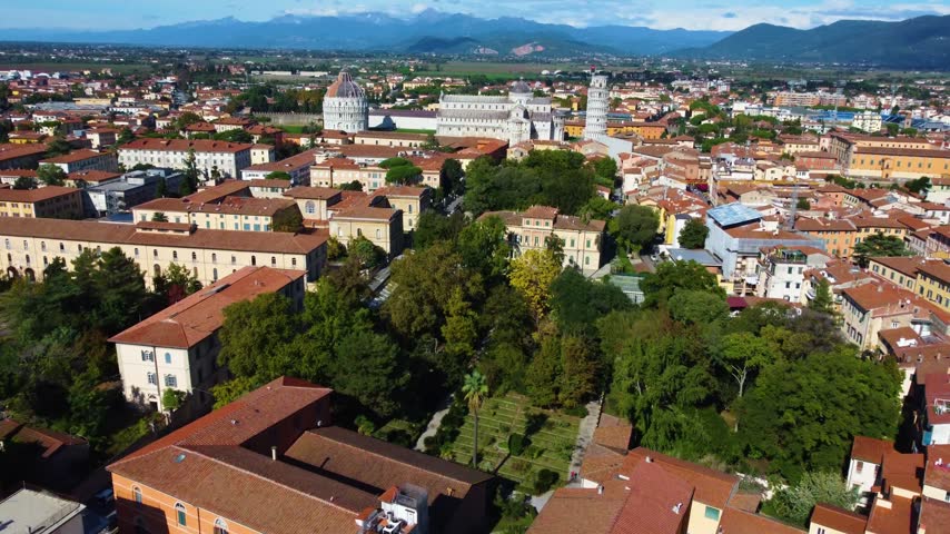 Stunning aerial footage flying over the orto e museo botanico, revealing the historic cityscape of pisa with its famous landmarks