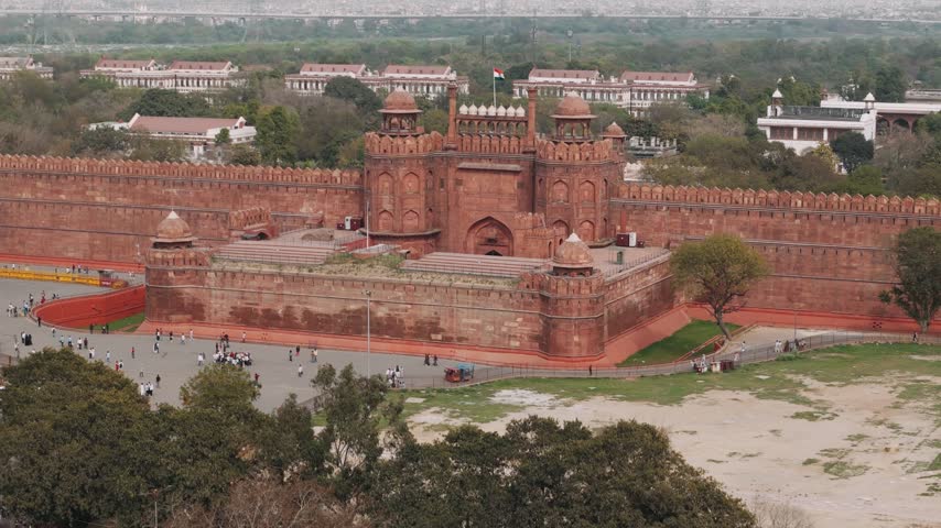 Aerial view of the historical red fort monument in delhi with the indian flag waving on the lahore gate.