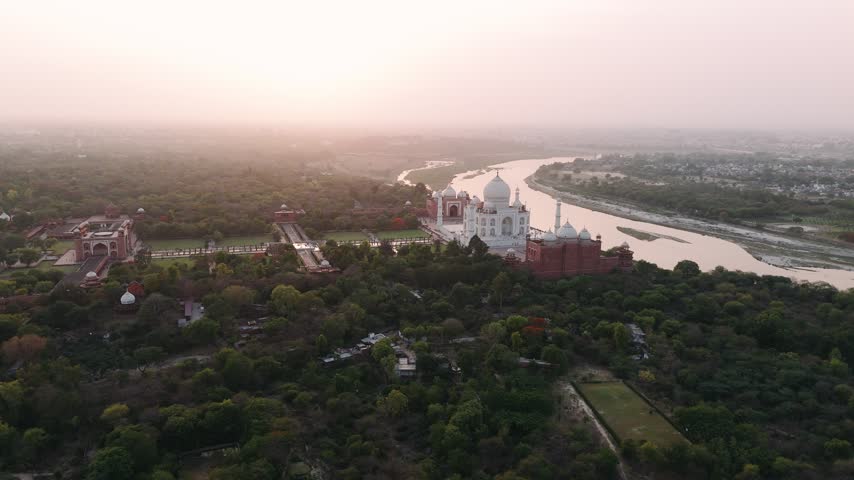 Aerial view of taj mahal, a unesco world heritage site in india. The famous white marble mausoleum sits beside the yamuna river.