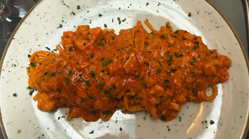 Pasta with lemon and salmon in creamy tomato sauce, Italian dinner dish.
