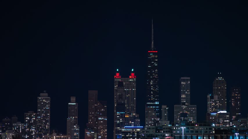 Full moon rising over chicago skyline at night with illuminating skyscrapers and glowing city lights, dynamic establishing shot.
