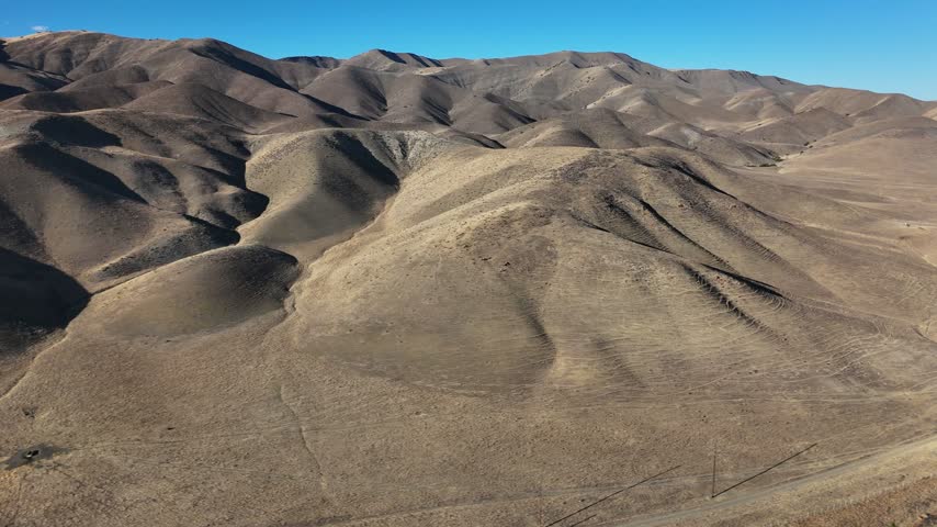 Aerial view of dry creek bed winding through arid rolling hills in Paso Robles