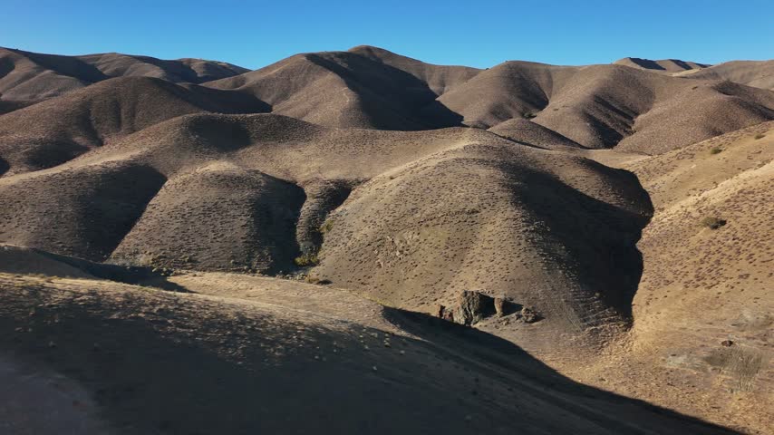 Aerial view of dry creek bed winding through arid rolling hills in Paso Robles