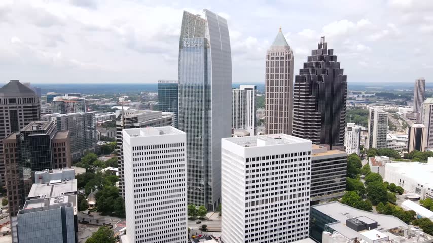 High altitude aerial footage capturing urban architecture and dense cityscape of Atlanta Georgia with clear cloudy sky background.