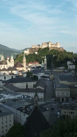 A vertical perspective of the historic cathedral and medieval fortress in Salzburg, Austria, captured from a high aerial viewpoint.