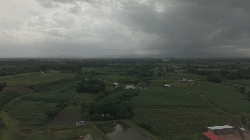 Scenic aerial shot of a farming community with scattered homes and lush green plantation.