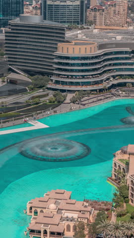 Looking down at Downtown Dubai, this timelapse captures the massive turquoise fountain complex nestled in the downtown lake. The vibrant blue waters contrast sharply with the surrounding pavement.