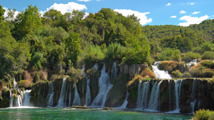 Beautiful waterfall in Krka National Park, Croatia, with lush green forest and turquoise water