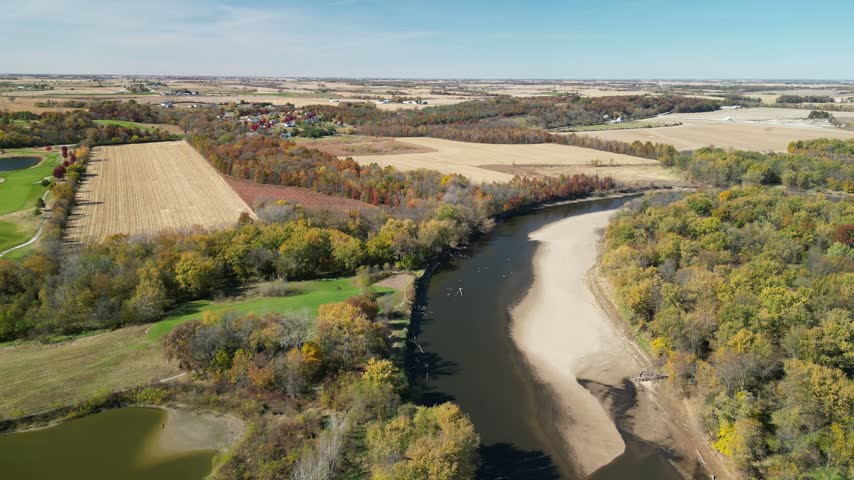 Flying along the Iowa River in Southeastern Iowa in the fall. Farm fields and forests dot the landscape while sand bars and water flow in the river. drone, 4k, flying