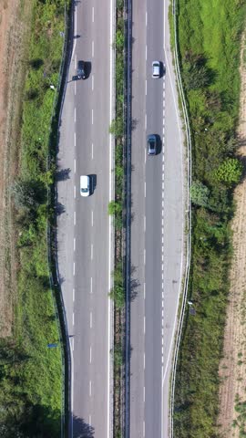 Cars and trucks travel along a provincial road near Milan, viewed directly from above.