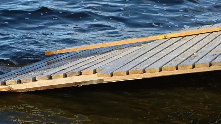 A wooden dock extends into a body of water, perfect for fishing or relaxation.