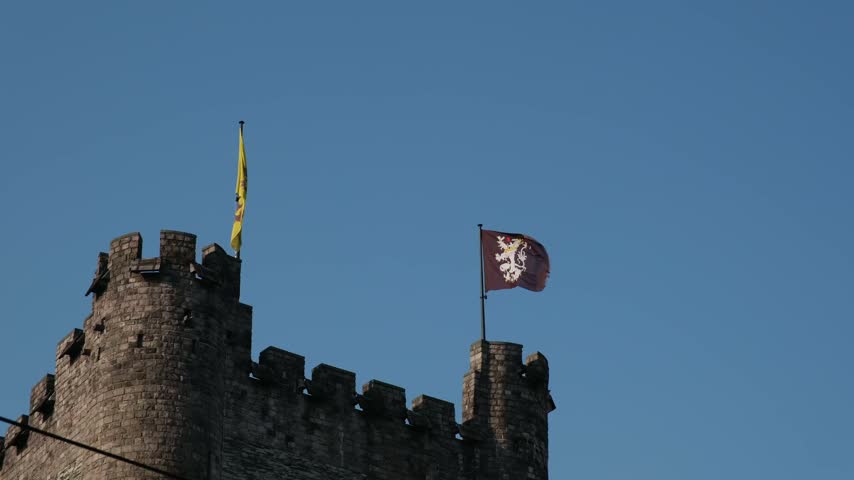 Historical stone castle tower with flying flags in Belgium city Ghent for tourism project