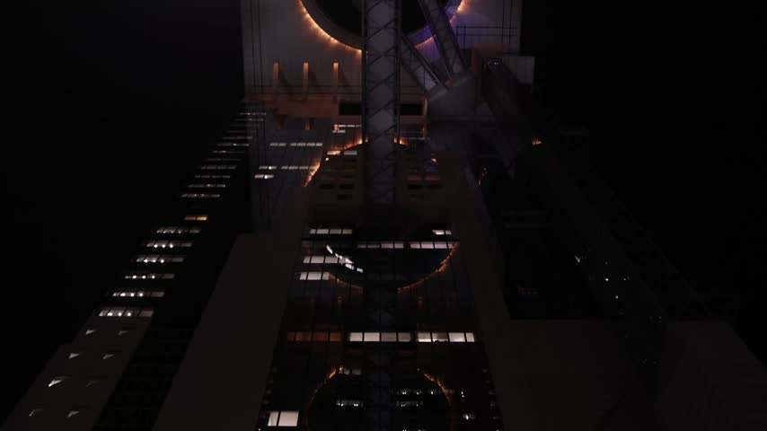 Night view of the futuristic glass Sky Escalator inside the Umeda Sky Building in Osaka, Japan, leading toward the Floating Garden Observatory high above the city