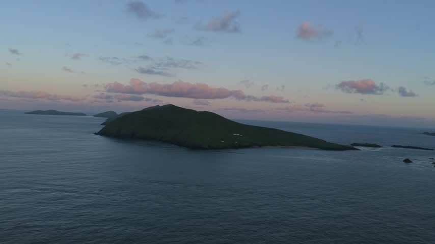 Twilight aerial view of Great Blasket Island off the Dingle Peninsula, with a rugged headland and small islands silhouetted over the Atlantic Ocean.