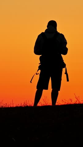 Orange sunset over Eemshaven tidal flats with a lone silhouetted person.