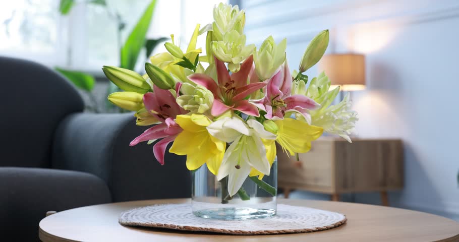 Bouquet of beautiful lilies in vase on table indoors