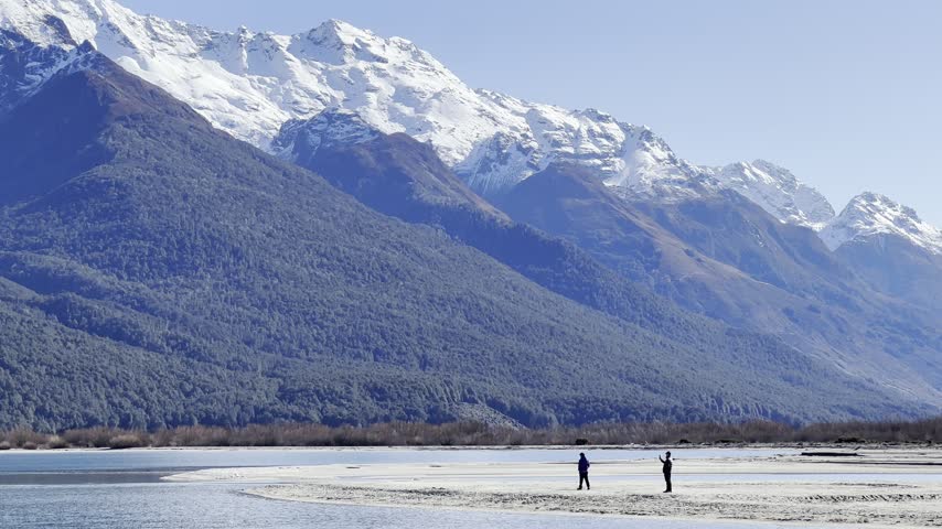 Two person walking by the shore
