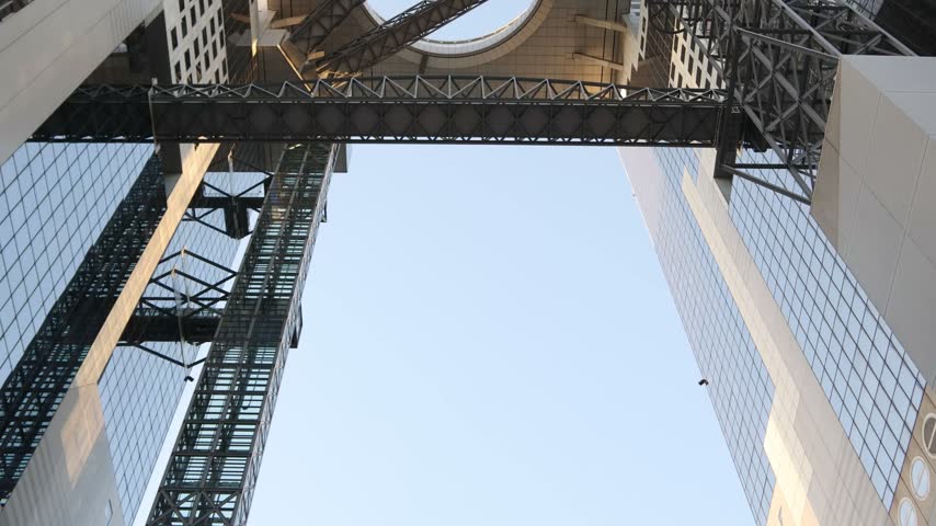 Low-angle architectural view of the Umeda Sky Building in Osaka, Japan, highlighting its massive steel framework, elevated connecting structures and distinctive modern engineering