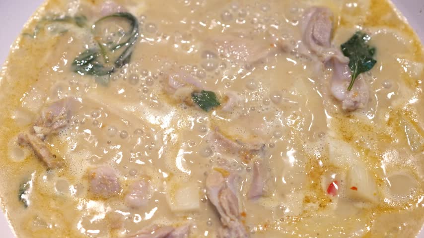Creamy Seafood Soup with Mushroom, Squid, Herb Garnish, and Onion in Bowl