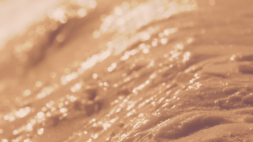 Glittering alpine snow surface catches warm low sunlight in an abstract close-up