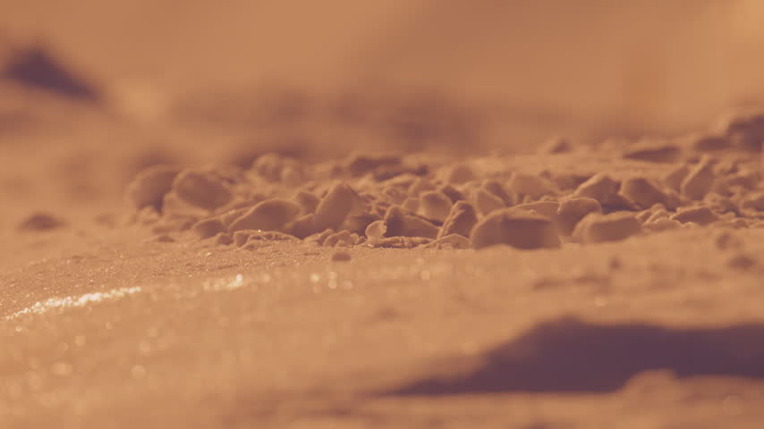 Sunlit clumps of alpine snow form a textured foreground in shallow focus