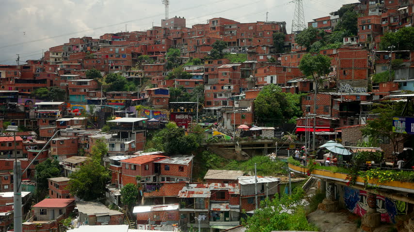 Dense Red Brick Houses Built Along The Steep Hillsides Of Comuna 13 District In Medellín, Colombia. - wide shot