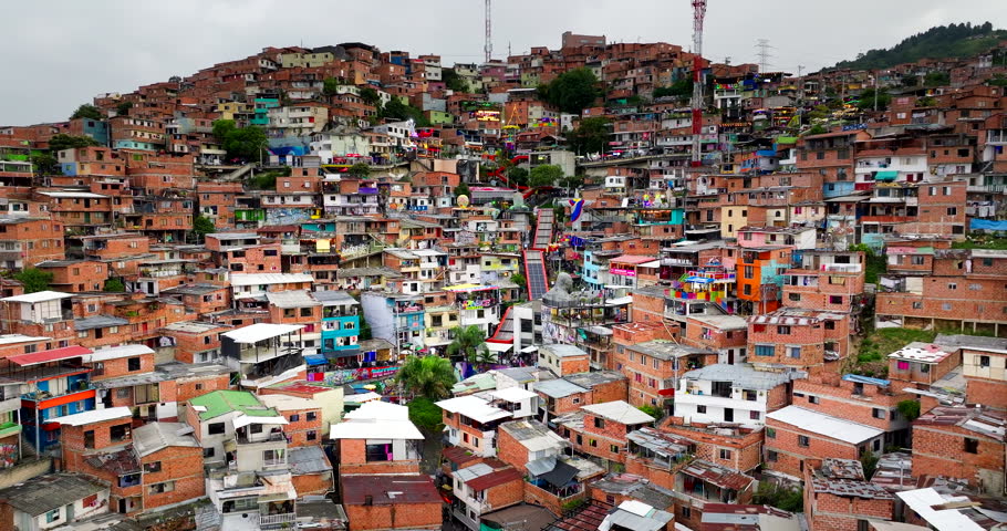 Comuna 13, Medellin, Colombia, showing densely packed hillside shanty housing, colourful homes and sprawling residential development across the urban district, aerial view