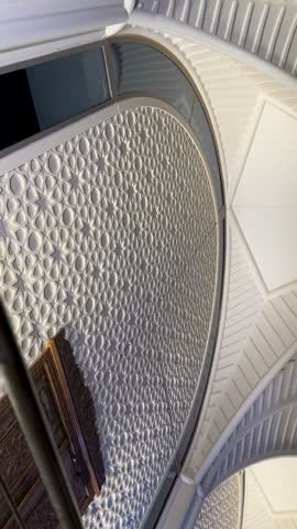 Panning shot of illuminated modern Islamic architecture with geometric patterns at Saudi airport.