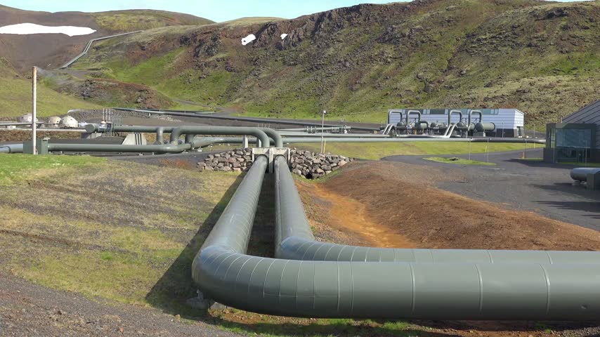 Industrial geothermal plant pipelines carrying energy across volcanic terrain in Iceland providing sustainable power source.