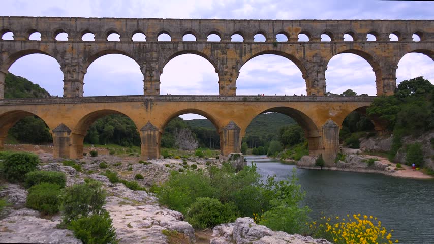 Ancient Roman aqueduct stone bridge spanning Gardon River France impressive historical engineering landmark cinematic footage.
