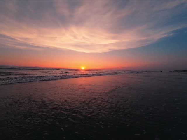 Sunset Over Ocean Waves and Beach Shoreline