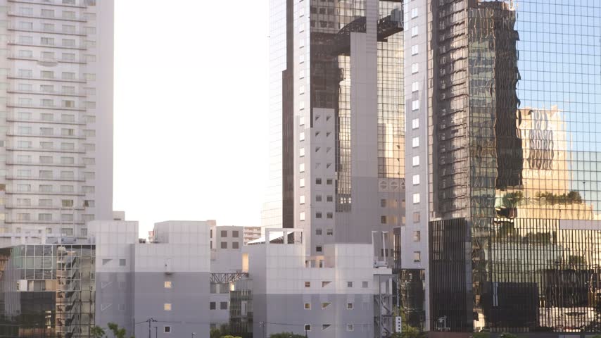 tilt up viww of modern high-rise buildings in the Umeda district of Osaka, Japan, showcasing the dense architecture and contemporary skyline of the city center