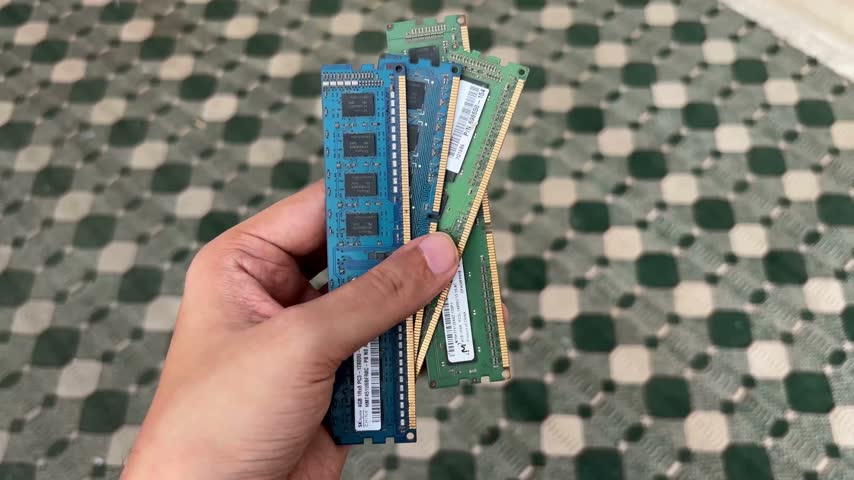 Close up view of hand holding multiple computer RAM memory modules highlighting electronic circuit hardware components for digital data processing and personal computer system upgrades and maintenance