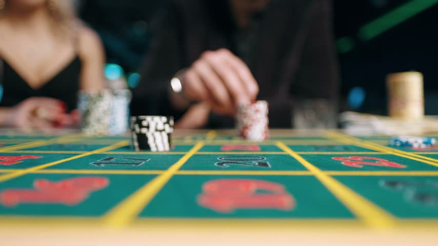 Player placing chips on green casino table. Poker game, gambling bet, roulette and card room entertainment concept