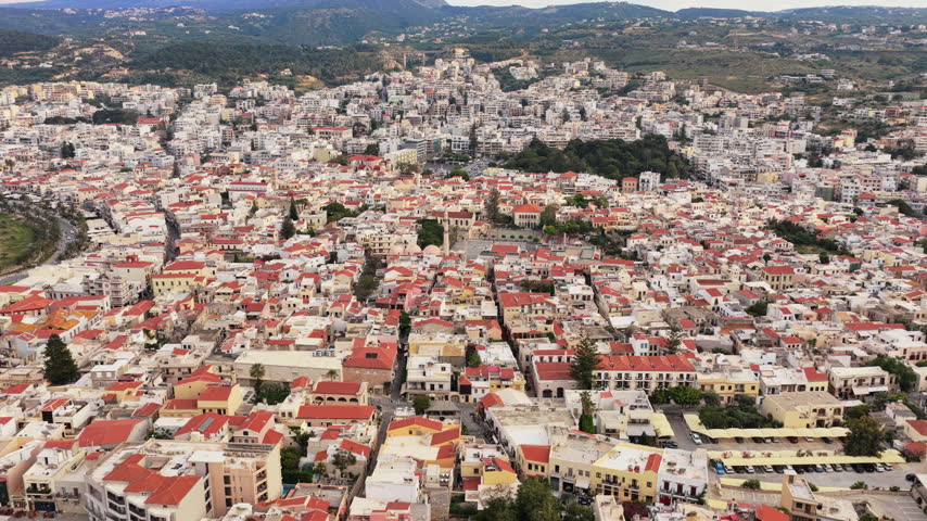 Aerial drone view of red-tiled old town rooftops and the Neratze Mosque minaret in the historic center, Rethymno, Greece