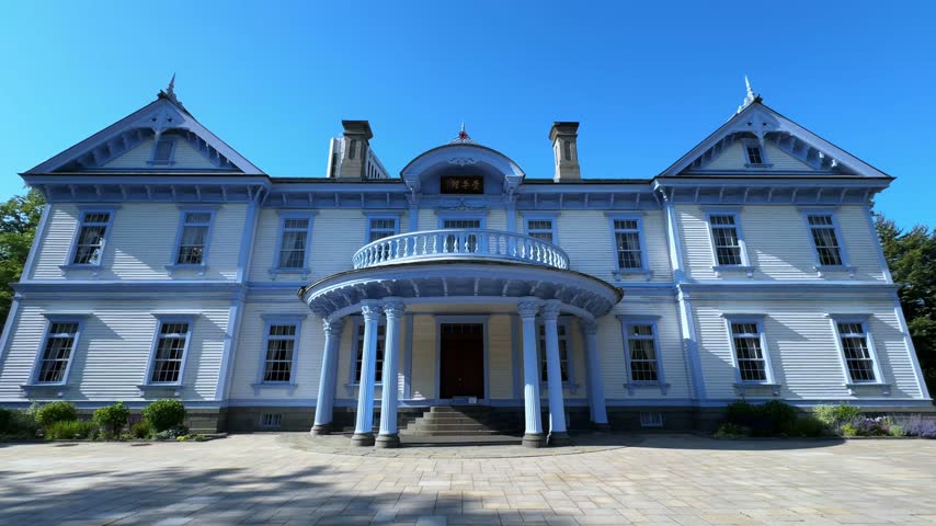 Historic Western Style Mansion and Garden Under a Clear Blue Sky