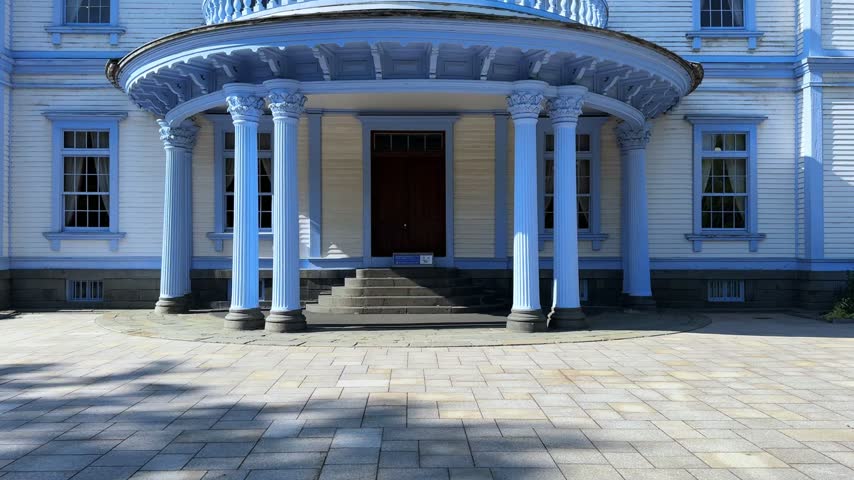 Historic Western Style Mansion and Garden Under a Clear Blue Sky