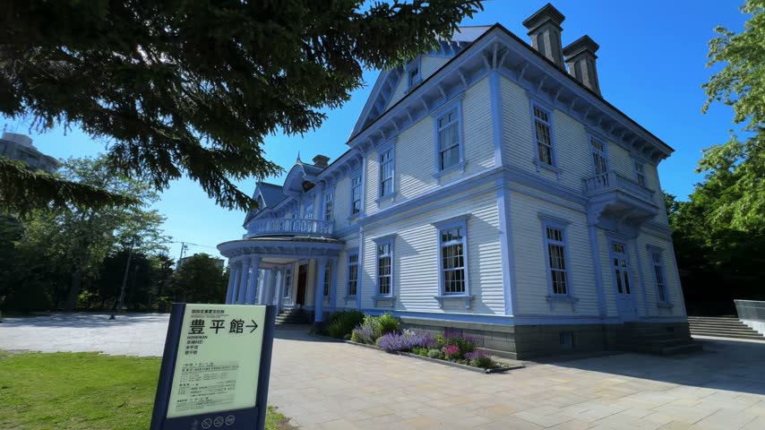 Historic Western Style Mansion and Garden Under a Clear Blue Sky