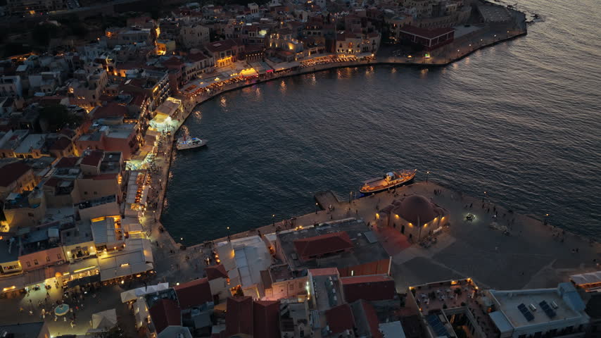 Aerial drone view of the old Venetian harbor and the domed Kucuk Hasan mosque at blue hour, Chania, Greece